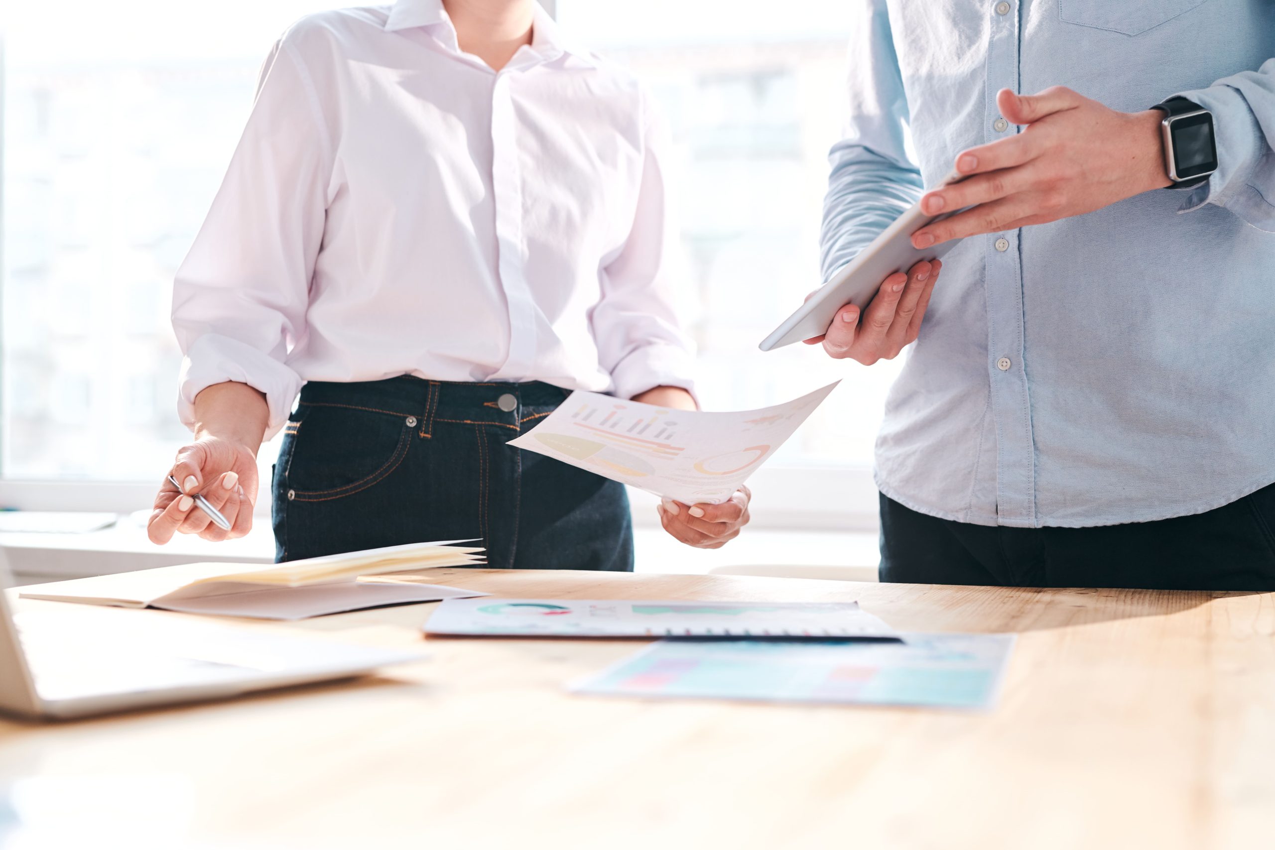 Business professionals reviewing documents and discussing strategy during a meeting.